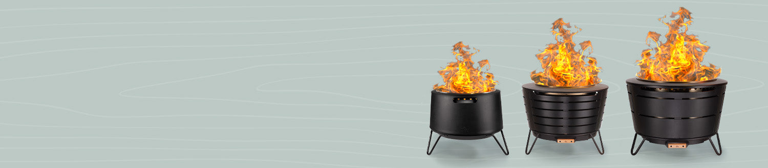 Three TIKI® fire pits of different sizes with bright flames, displayed on a light woodgrain background.