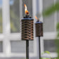 Brown woven torch with flame, outdoor decor.