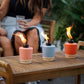 Tiki torches in coral, mint, and orange on a wooden table.