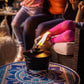 Black tabletop heater with flame, on patterned table.