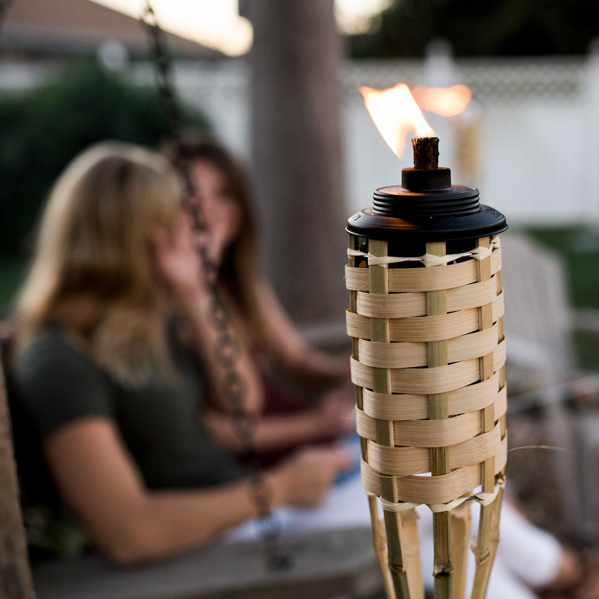 Natural bamboo torch with black base and flame, outdoor decor.