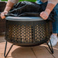 Dark gray Tiki fire pit with circular perforated design and black cover.