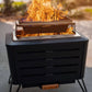 Black portable fire pit with mesh lid and flames.