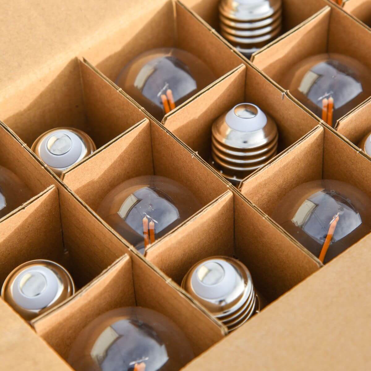 Brown cardboard box containing multiple light bulbs with orange wires.
