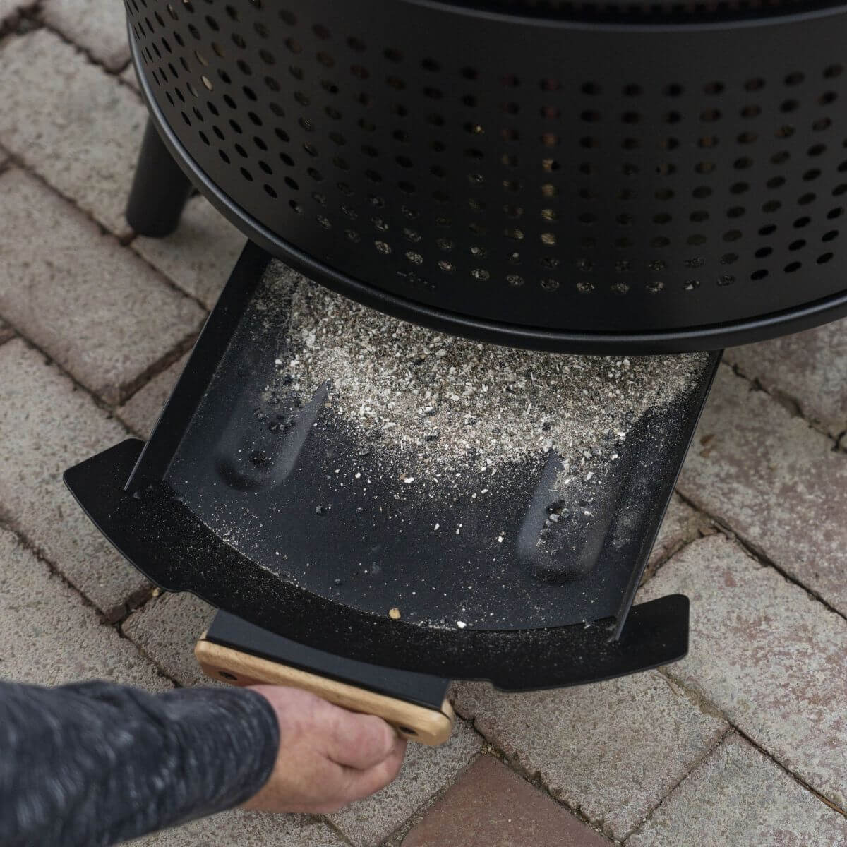 Black outdoor grill with ash tray and wooden handle.