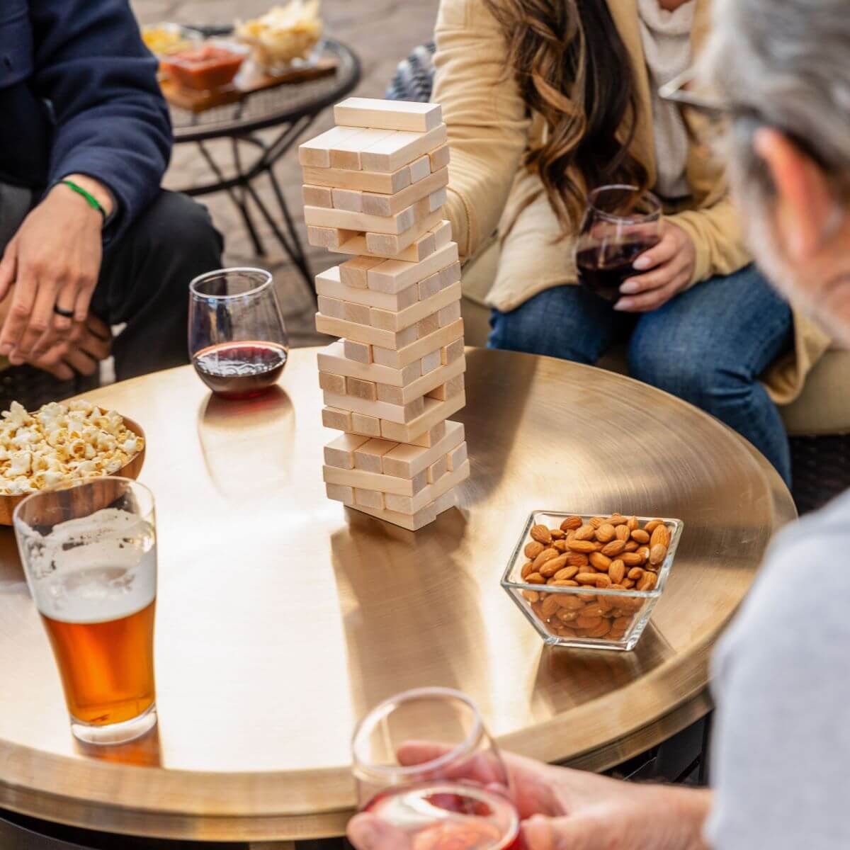 Stackable wooden blocks forming a tower game on a table with snacks and drinks.