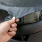 Gray car wheel cover being installed by hand.