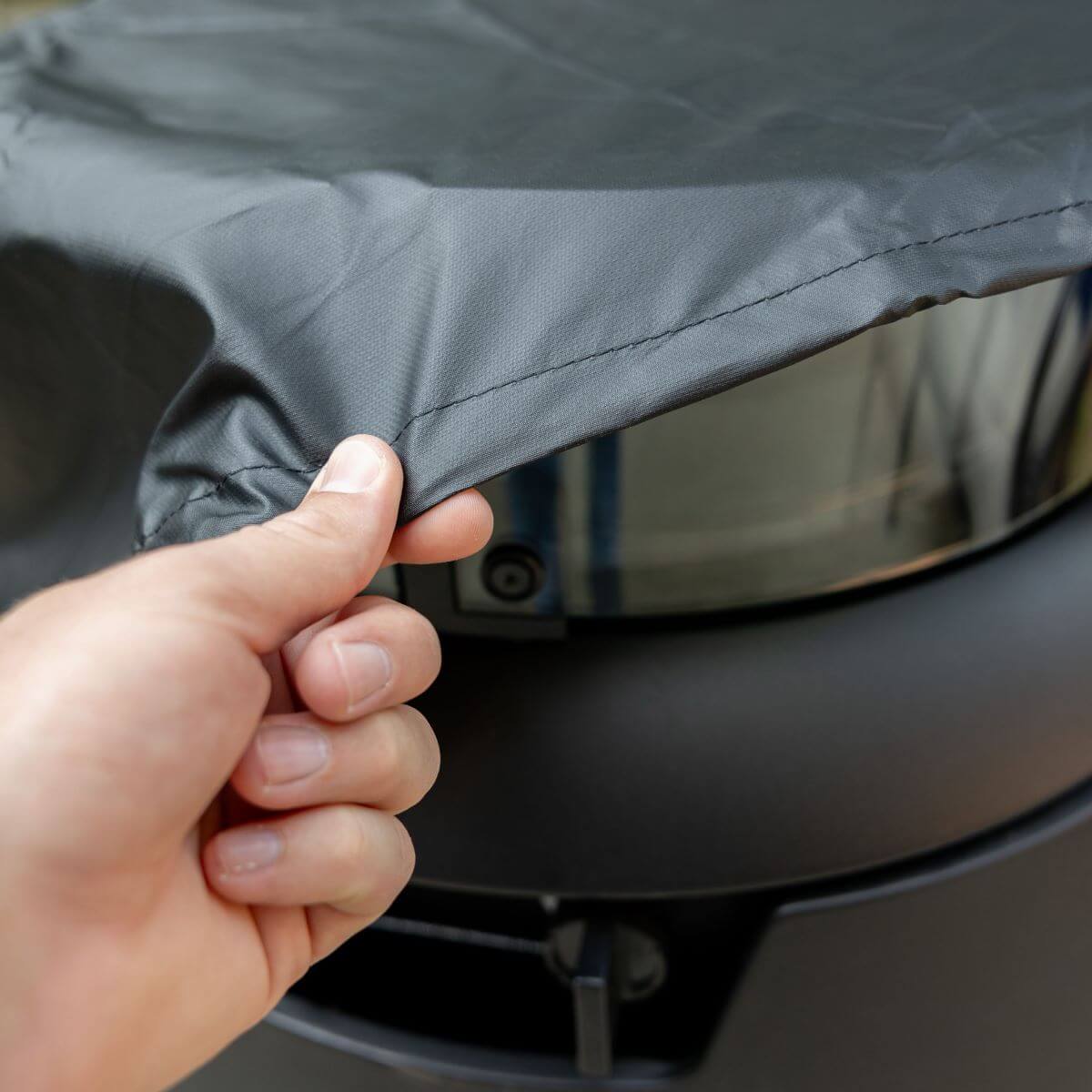 Gray car wheel cover being installed by hand.