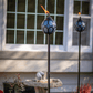 Blue decorative outdoor torches with flame, set on poles.