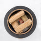 Black ceramic incense burner with wooden palo santo sticks inside.