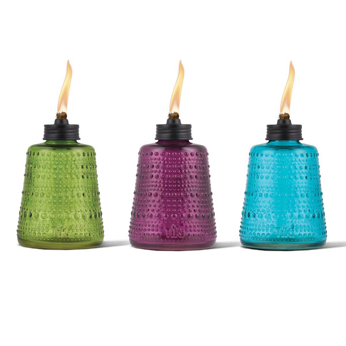 Colorful glass oil lamps in green, purple, and blue with flames.