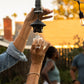 Black outdoor string light with glass bulb and metal accents.