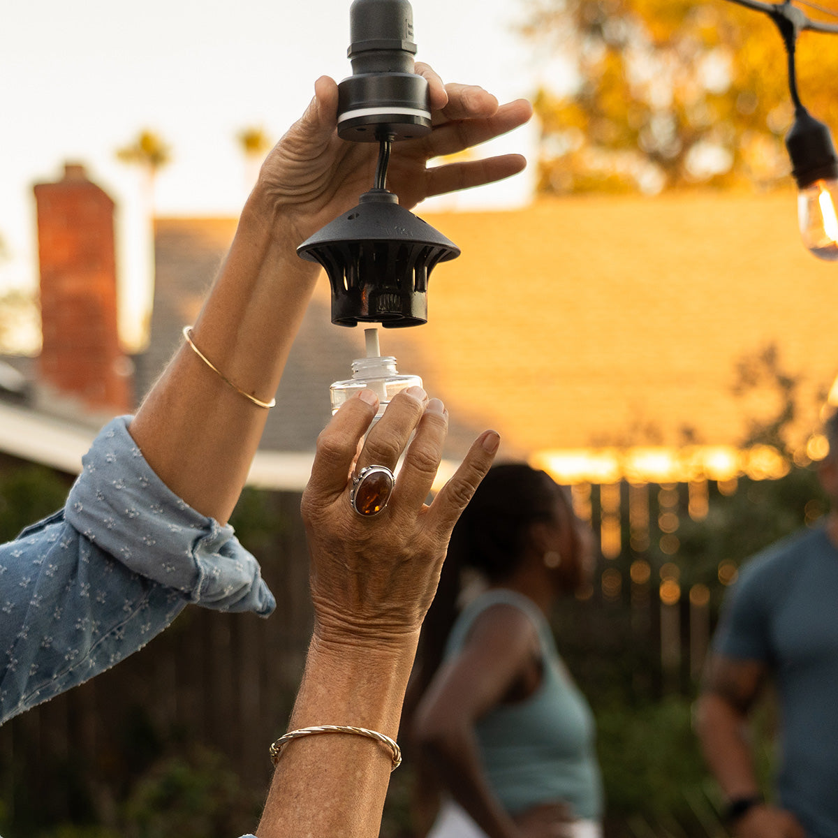 Black outdoor string light with glass bulb and metal accents.