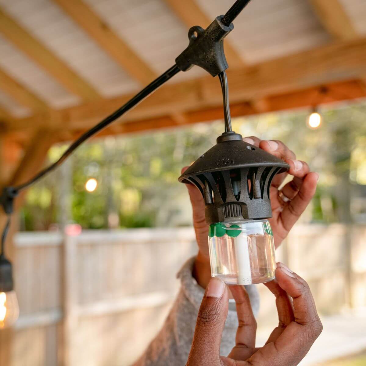 Black lantern-style outdoor light with clear glass and green accents.