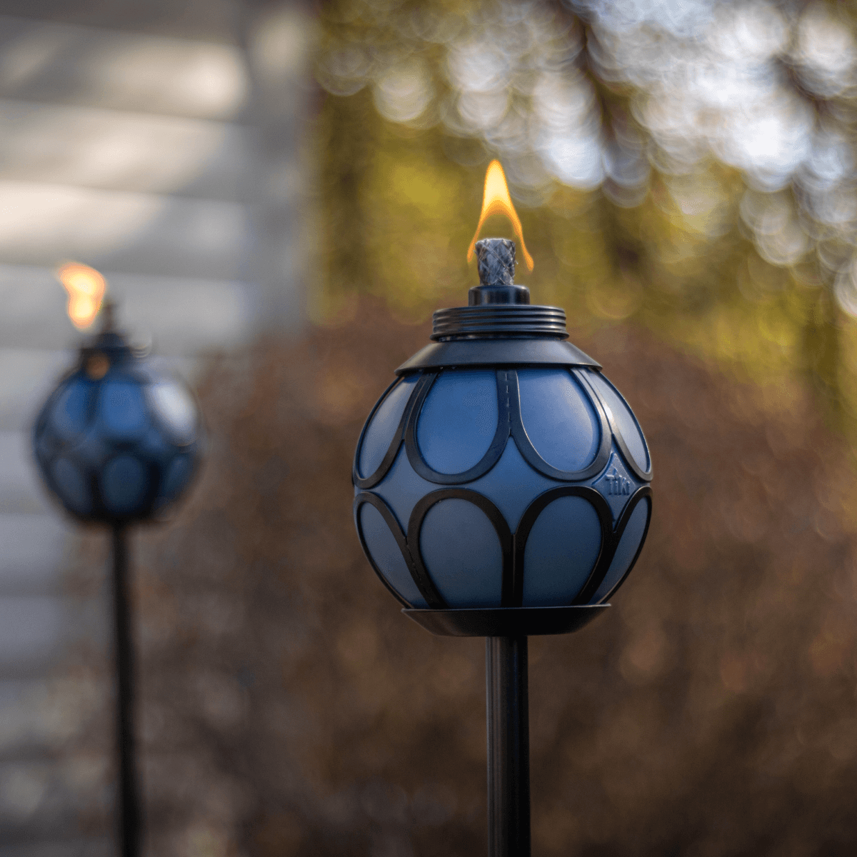 Blue Tiki torch with flame, outdoor lighting.