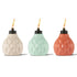 Three colorful ceramic tiki torches in cream, mint, and coral with flame.