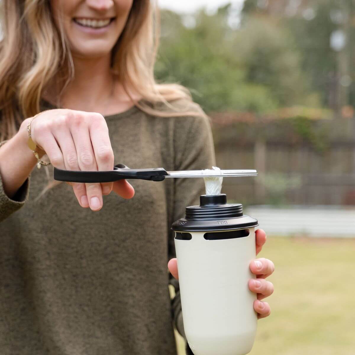 White Tula travel mug with black lid and straw attachment.