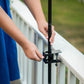 Black adjustable pole clamp attached to white railing.
