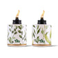 White Tiki torches with green leaf pattern and gold trim, lit.