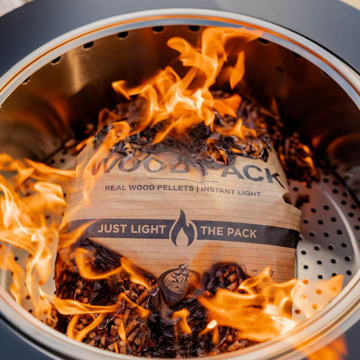 "Wood Pack real wood pellets instant light, burning in a grill."