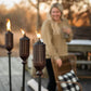 Brown outdoor tiki torches with flame, set on patio.