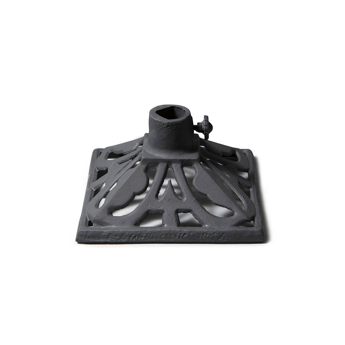 Black cast iron trivet with central hole and decorative pattern.