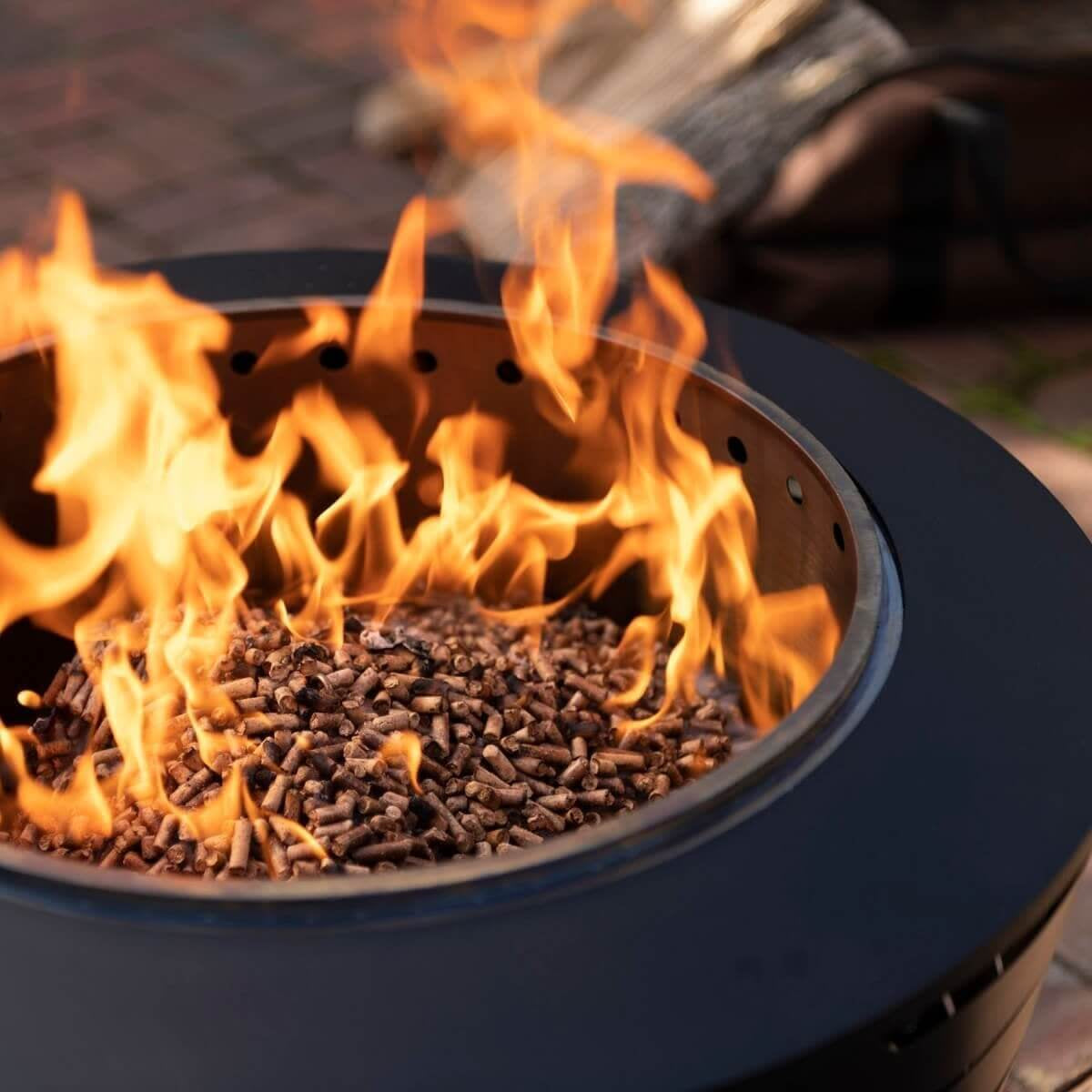 Blue fire pit with burning wood pellets, flames visible.
