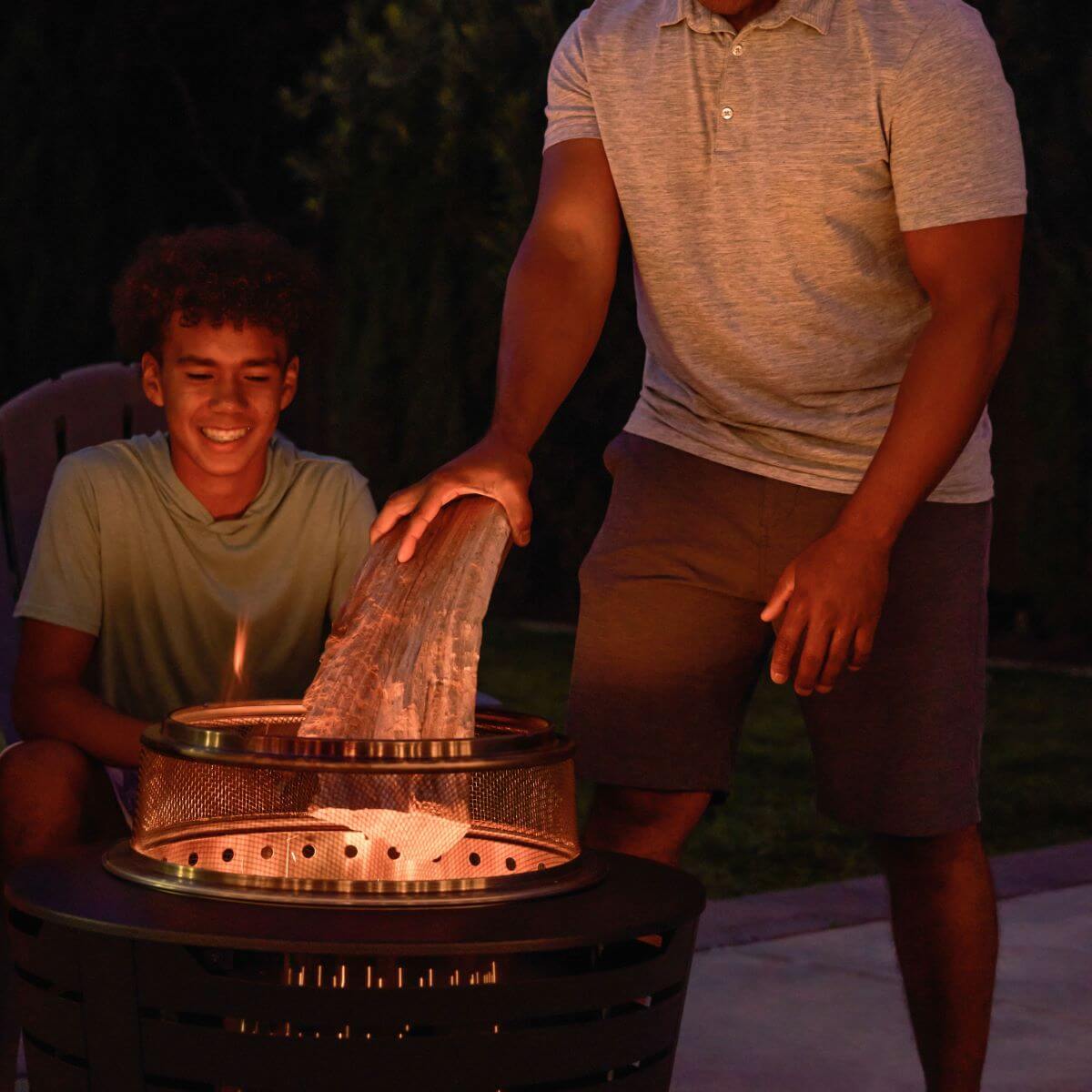 Outdoor fire pit with mesh cover and wood log, used for cozy outdoor gatherings.